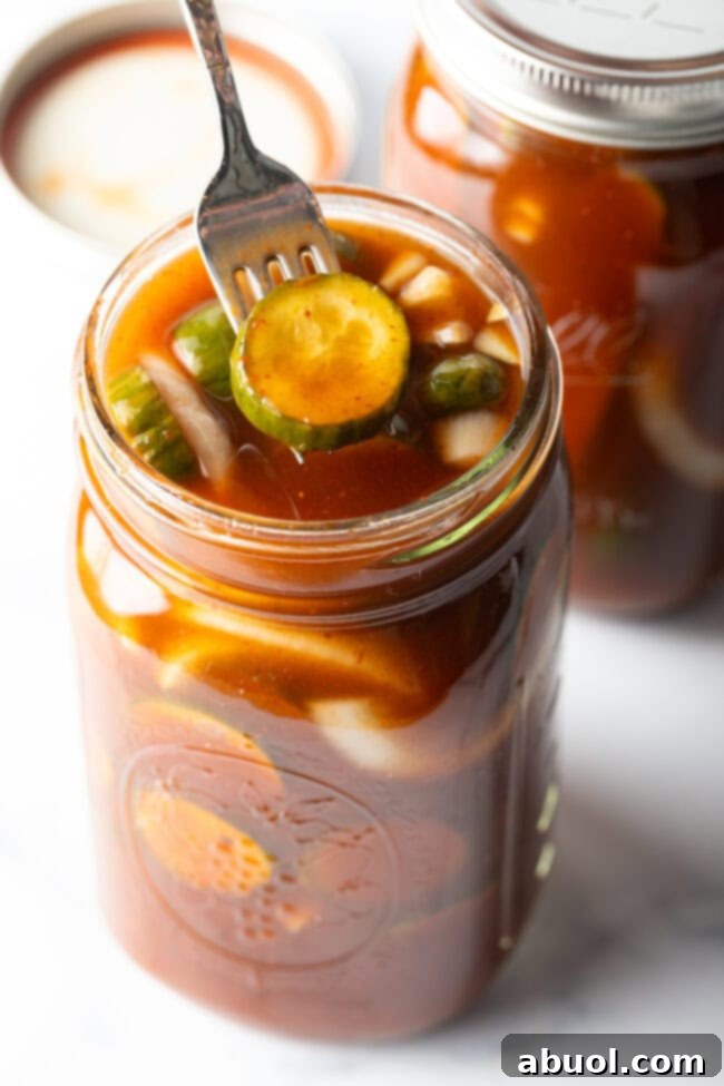 Fork pulling a chamoy pickle from the glass jar.