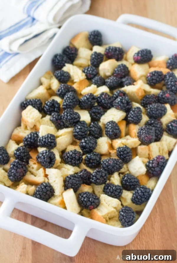 Bread and blackberries in a baking dish. 