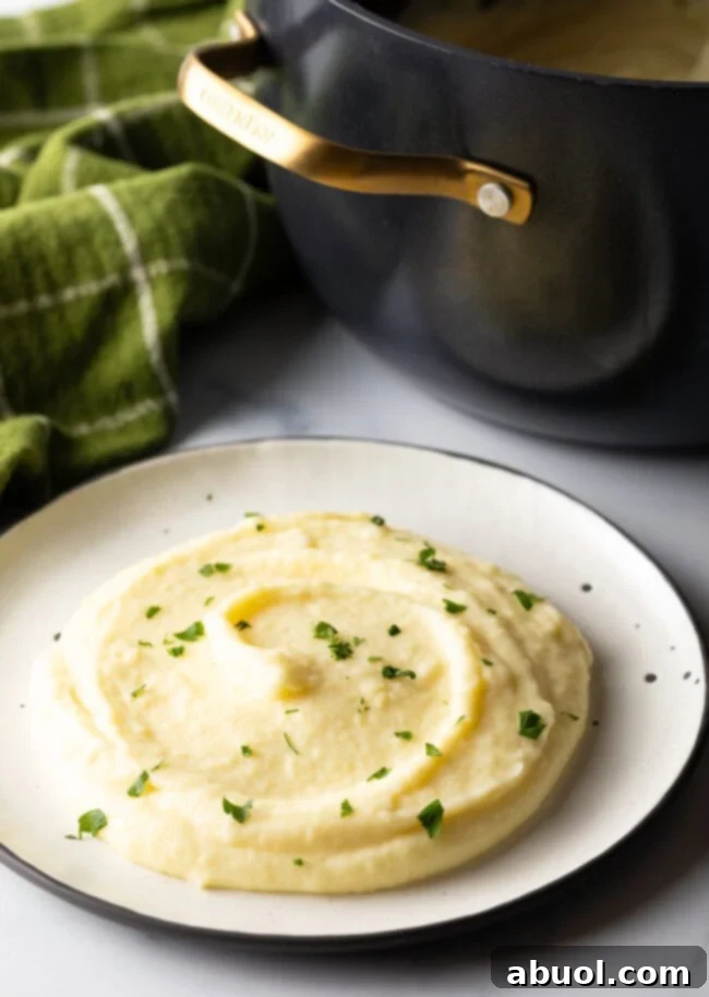 A pristine white plate holds a generous serving of rich, smooth pomme puree, ready to be enjoyed.
