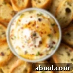 Bowl of whipped ricotta surrounded by slices of baguette, arranged around the ricotta like flower petals.
