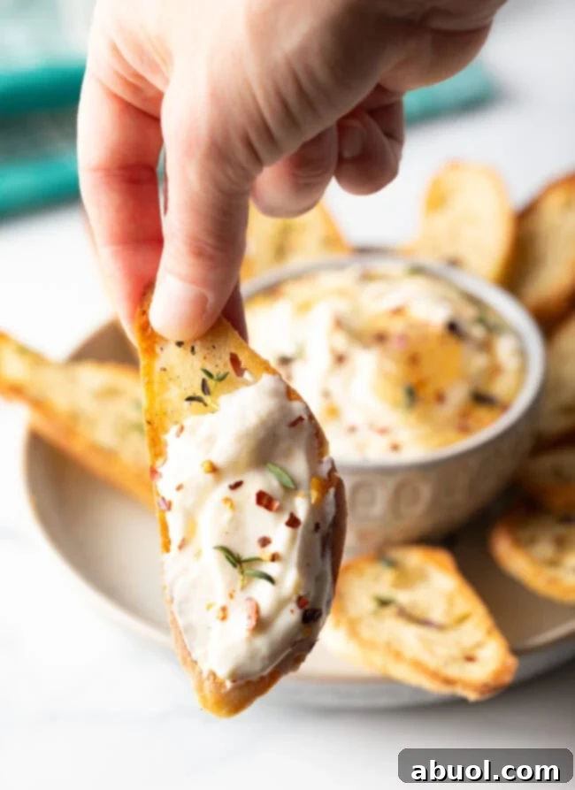 An overhead shot of a prepared whipped ricotta dip, showcasing its smooth, creamy texture in a white bowl, ready for garnishing or serving.