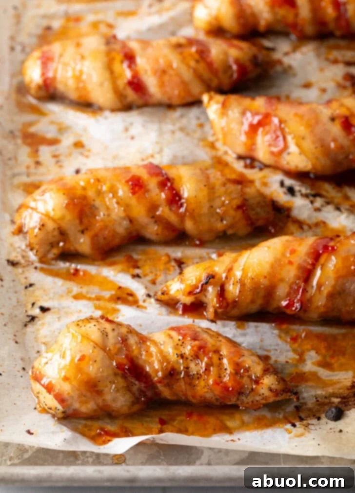 Mouthwatering Bacon-Wrapped Chicken 8 5 sweet and spicy Asian chili sauce coated bacon wrapped chicken tenders on skewers.