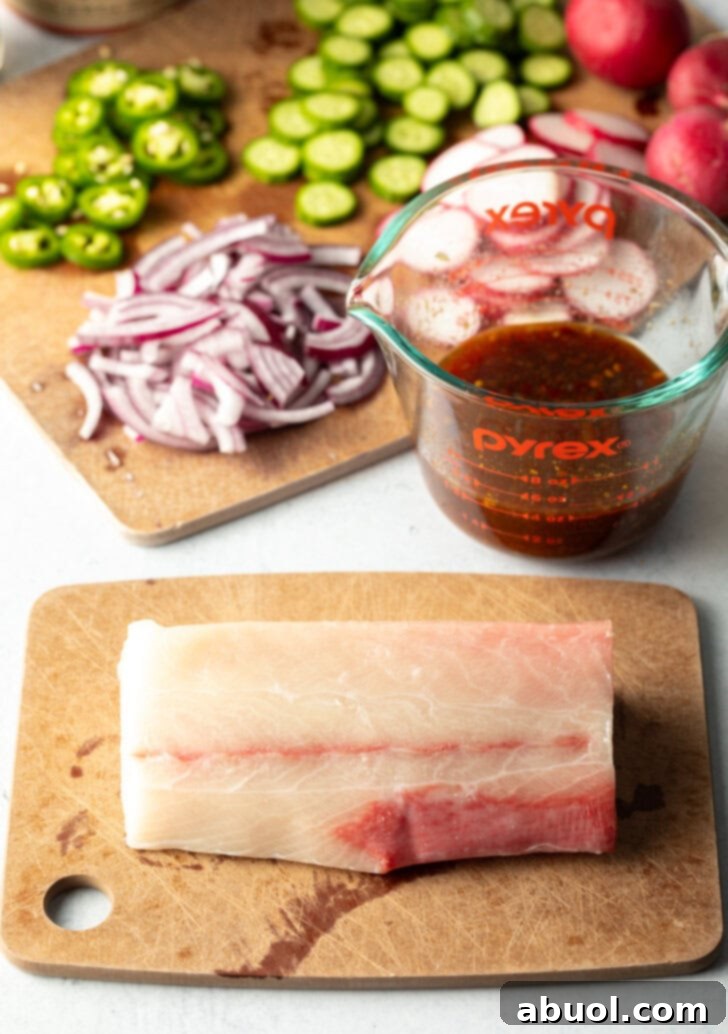 Large whole raw hamachi fillet on a cutting board.