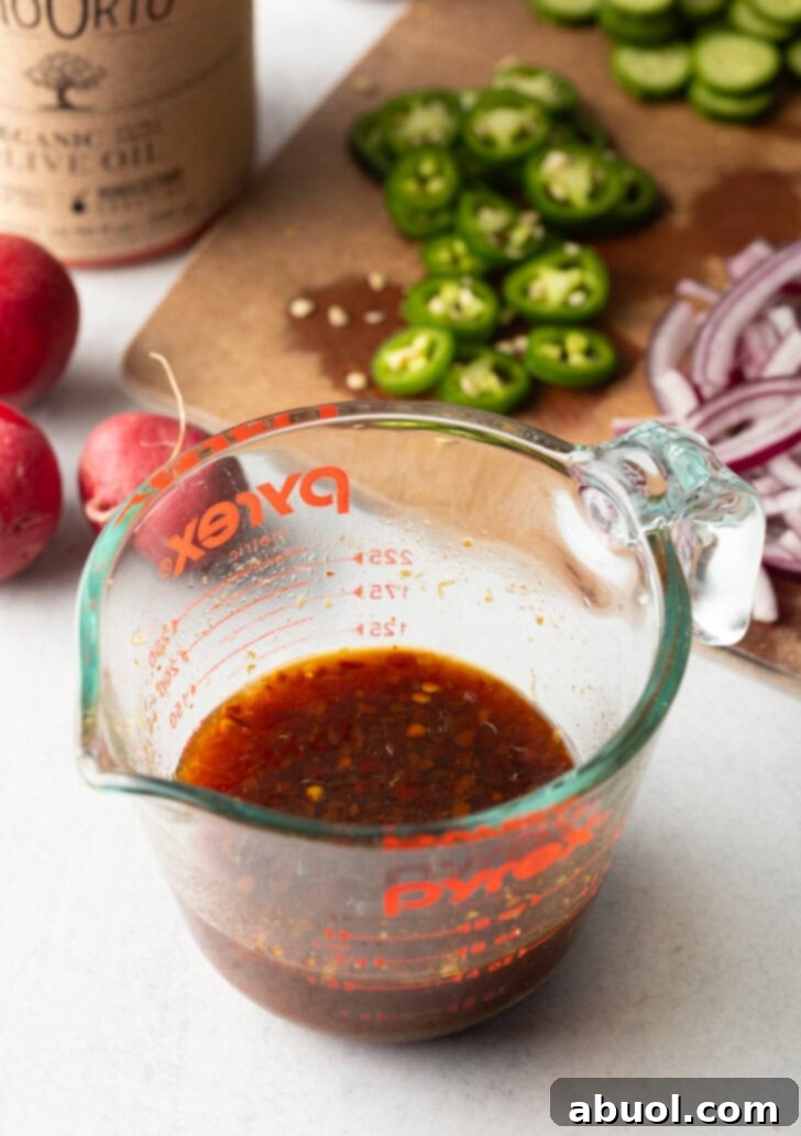 Glass measuring cup of soy and chili sauce.