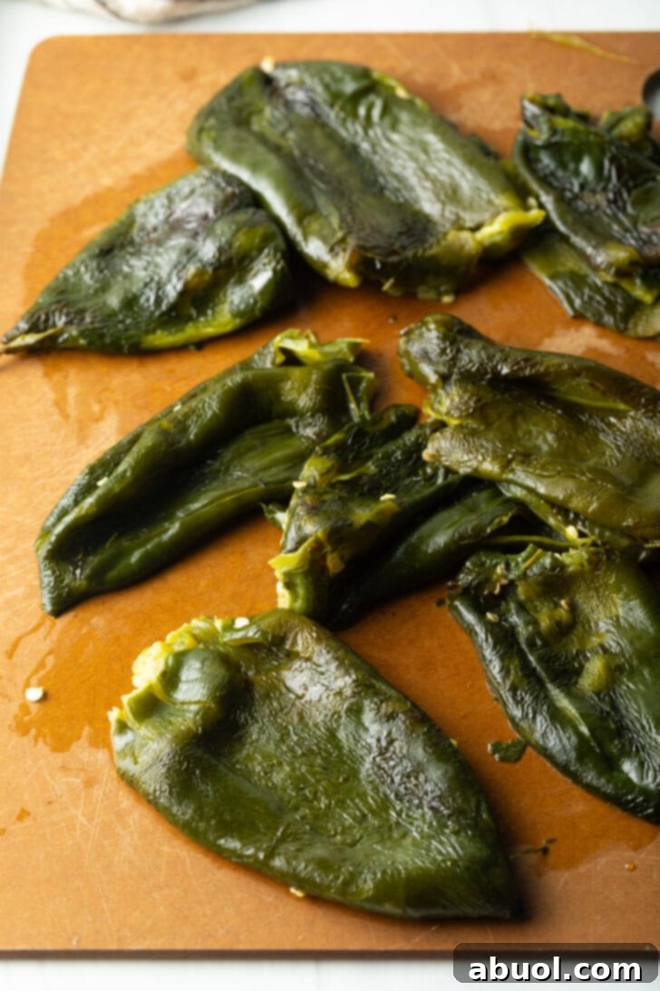8 roasted poblano pepper on a cutting board, seeds having been removed.