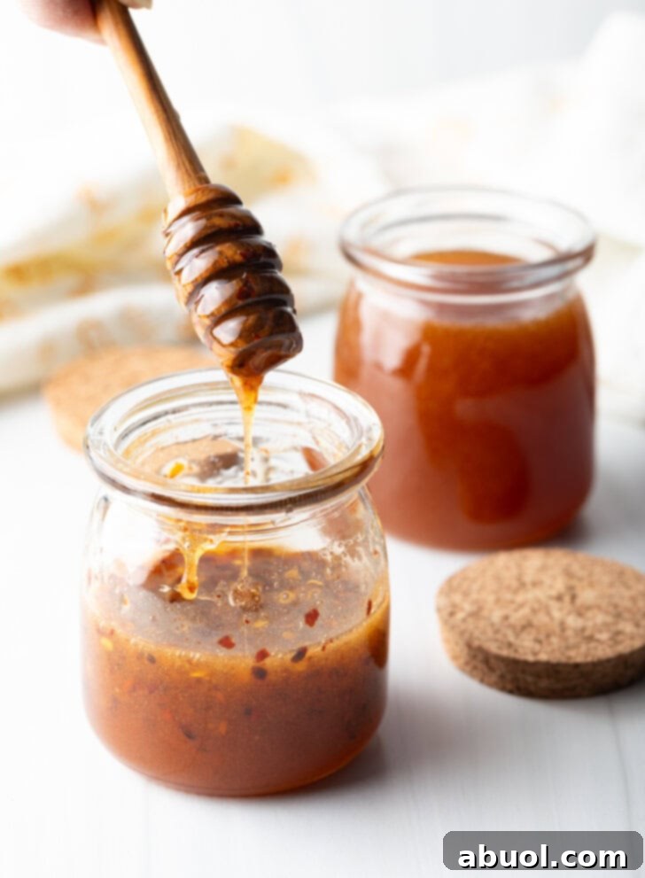 Sweet Heat Honey Blend 10 Two jars of honey honey. A honey spoon is showing a serving from the first jar.