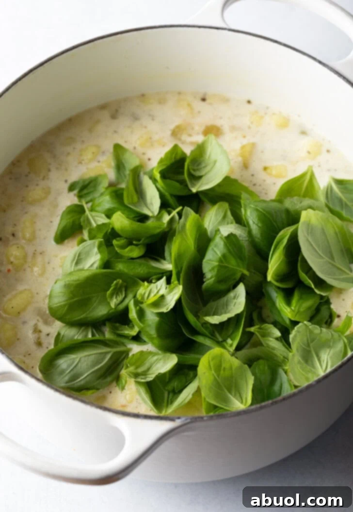 Adding fresh spinach to the cooking pot.