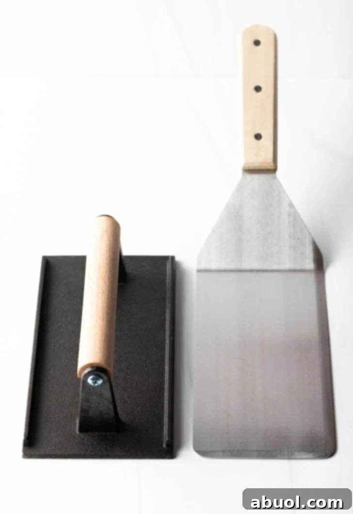 Side by side a flat press and a flat metal spatula.