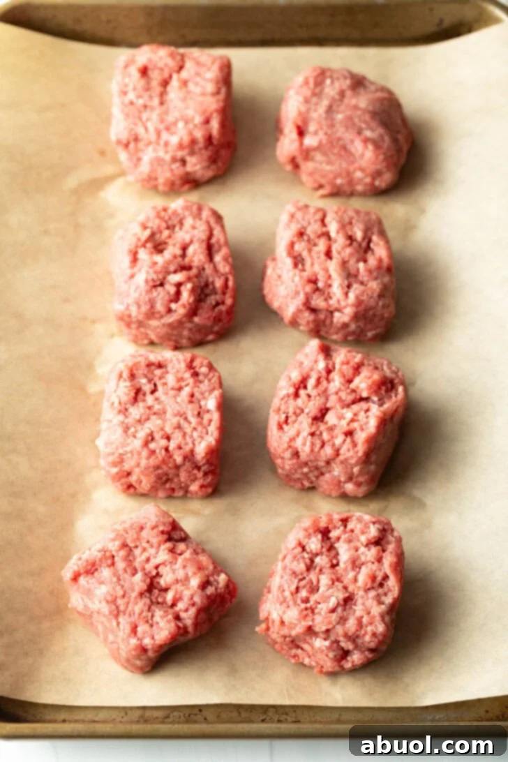 8 sections of ground beef on parchment paper.
