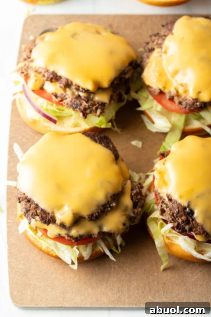 4 burgers topped with slices of cheese.