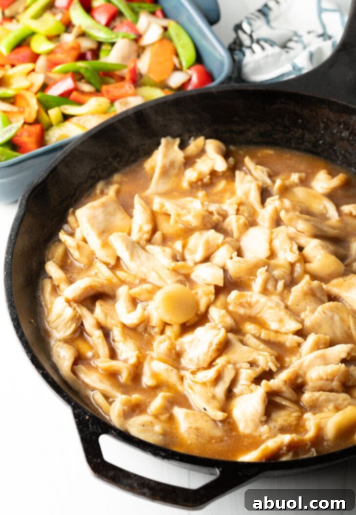 Cast iron skillet with chicken pieces and sauce.