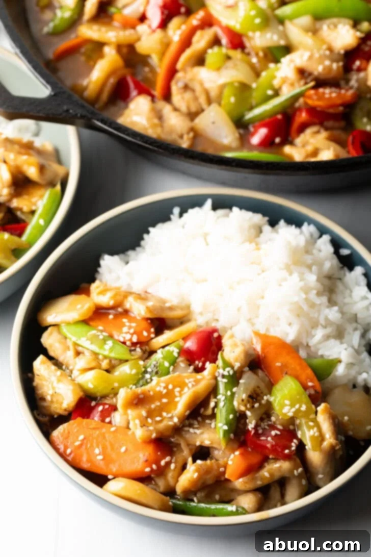 Bowl of American chicken chop suey nestled beside white rice.