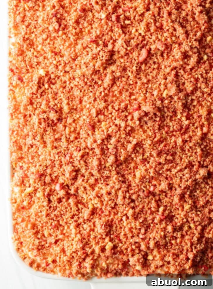 Berry Crumble Bliss Cake 13 A top-down view of the beautifully baked cake, lavishly adorned with its strawberry crunch crumble topping, showcasing its inviting texture and vibrant colors.