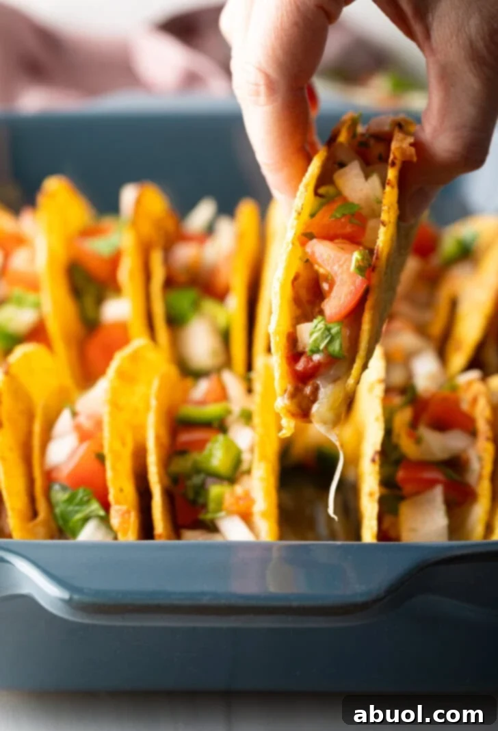 Hand picking up a taco from the tray.