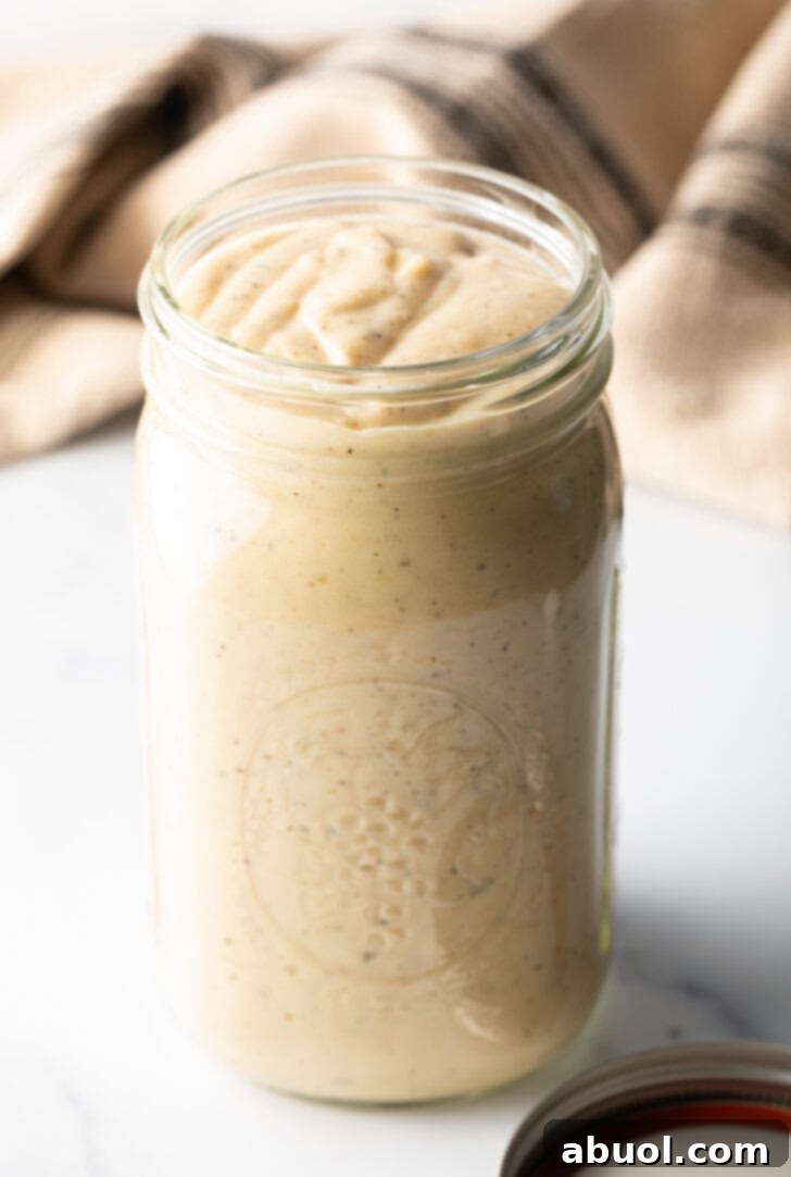 Large glass mason jar filled with homemade garlic and parmesan sauce.