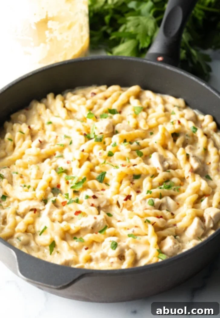 Black one pot with cooked pasta with garlic and parmesan.