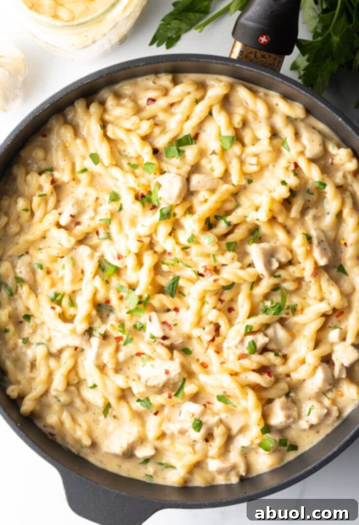 Top down view of black skillet with cooked pasta with garlic and parmesan.