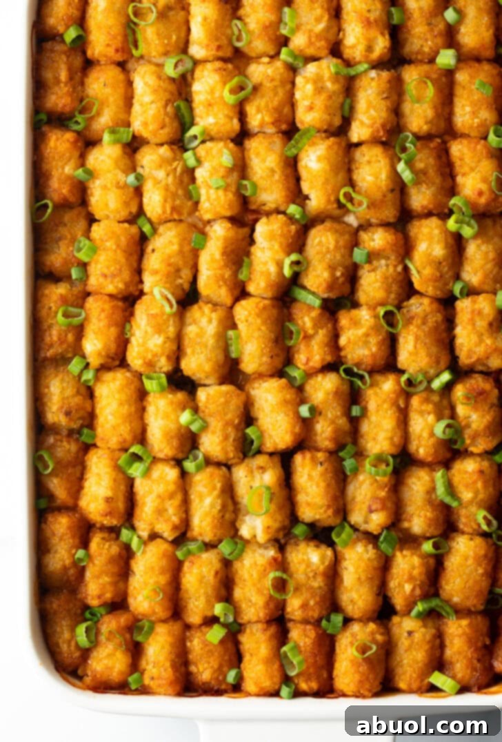 Fully baked cowboy tater tot casserole with rows of tater tots on top.