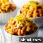 Hearty Beef and Macaroni Skillet 11 Three bowls of beefaroni topped with shredded cheddar cheese and chopped scallions.