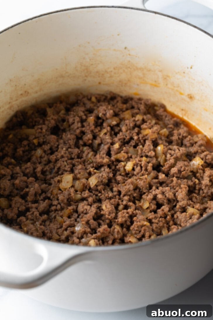 Hearty Beef and Macaroni Skillet 5 Crumbled ground beef browning in a large cooking pot, ready for the next step of the recipe.