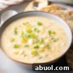 A beautifully presented bowl of creamy fish chowder, ready to be enjoyed with bread and a spoon.