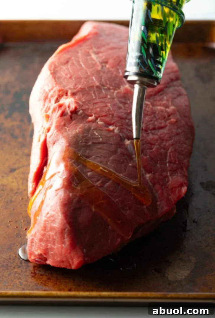 Classic Family Roast Beef 5 Coating a large piece of raw been with olive oil.