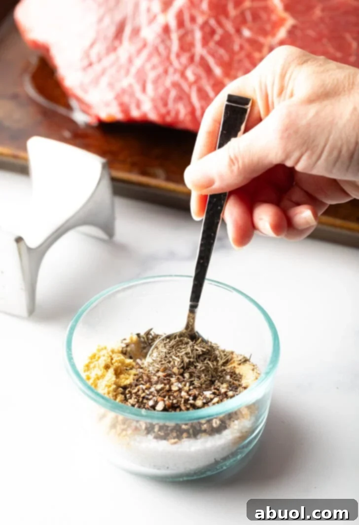 Classic Family Roast Beef 7 Hand stirring seasoning mix together in a small glass bowl.
