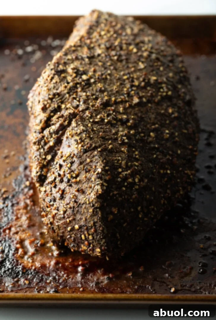 Classic Family Roast Beef 9 Top down view cooked beef round roast on a metal baking pan.