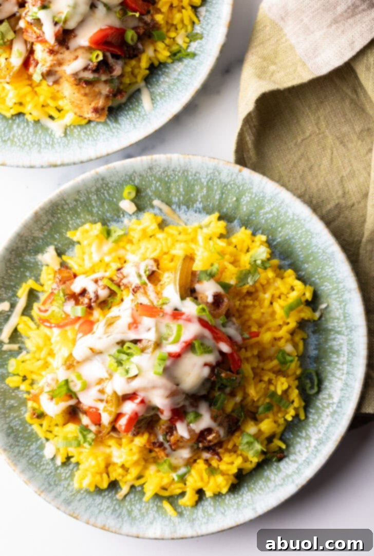 Chori pollo (chicken chorizo) covered in cheese on a bed of yellow rice.