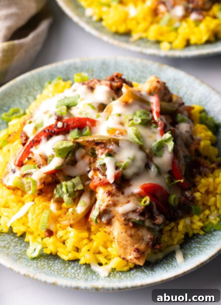 Chori pollo (chicken chorizo) covered in cheese on a bed of yellow rice.