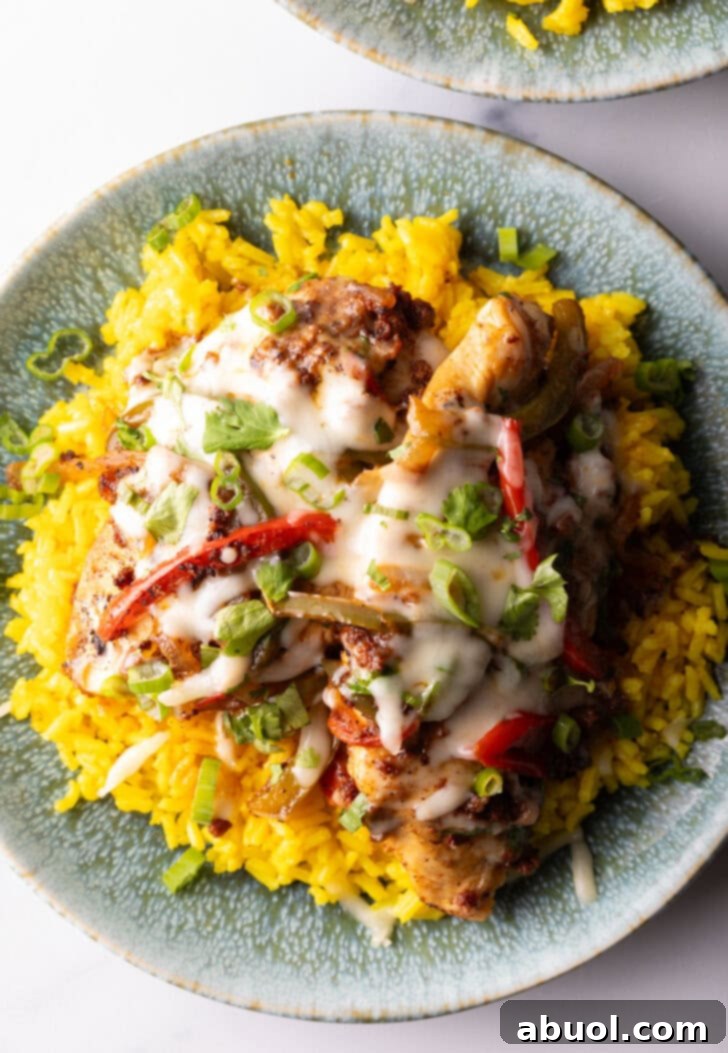 Chori pollo (chicken chorizo) covered in cheese on a bed of yellow rice.