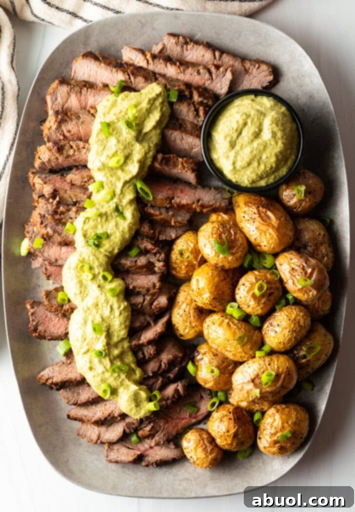 London Broil Marinade - London broil sliced into thick strips, covered with rich green sauce and chopped scallions with baby potatoes on the side.