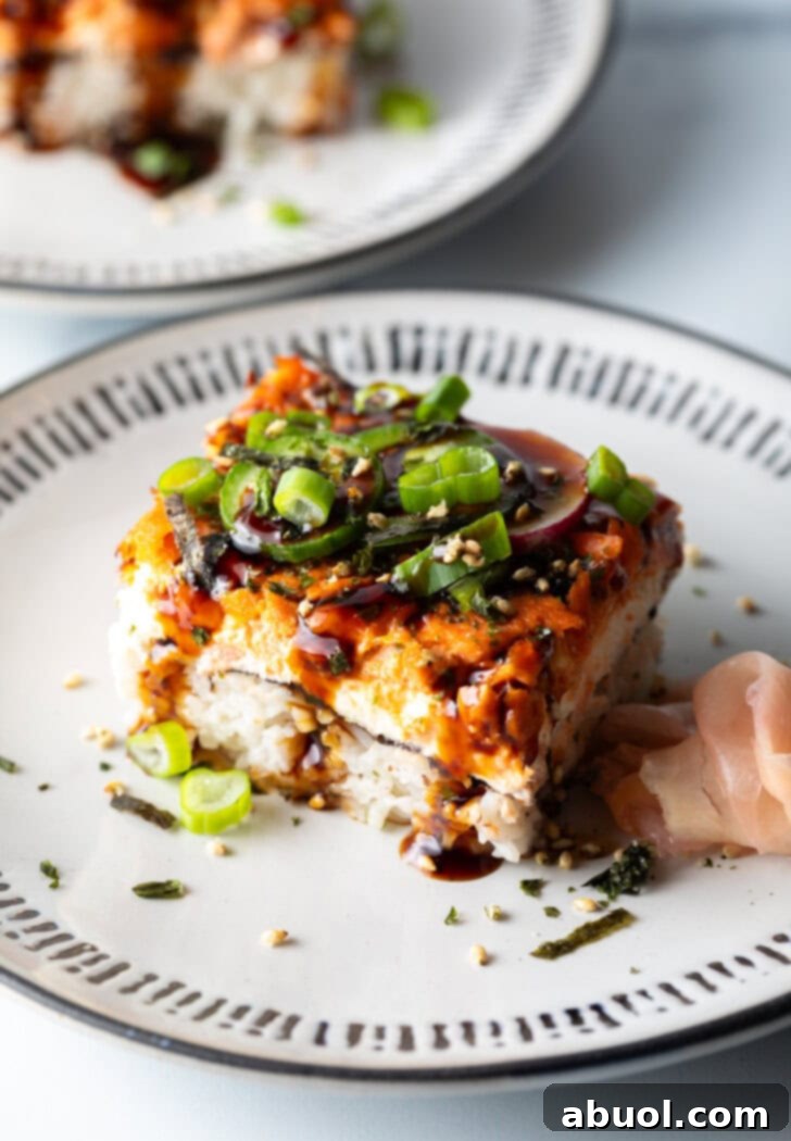 A single square of salmon sushi bake elegantly presented on a minimalist white plate, ready to be enjoyed.
