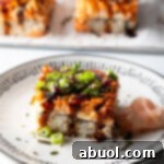 Square of salmon sushi bake on a white plate, garnished and ready to eat.