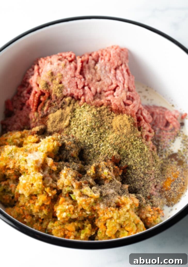 Slow Smoked Meatloaf 7 A close-up view of a large mixing bowl filled with the raw meatloaf mixture. The ground beef is perfectly combined with finely minced vegetables, breadcrumbs, and spices, indicating it's ready for shaping.