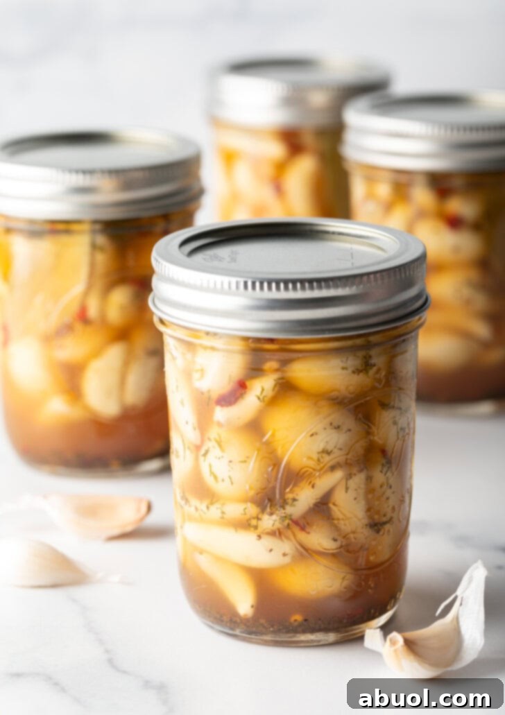 Glass jars of pickled garlic sealed with metal lids.