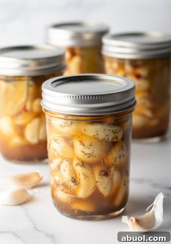 Glass jars of pickled garlic sealed with metal lids.