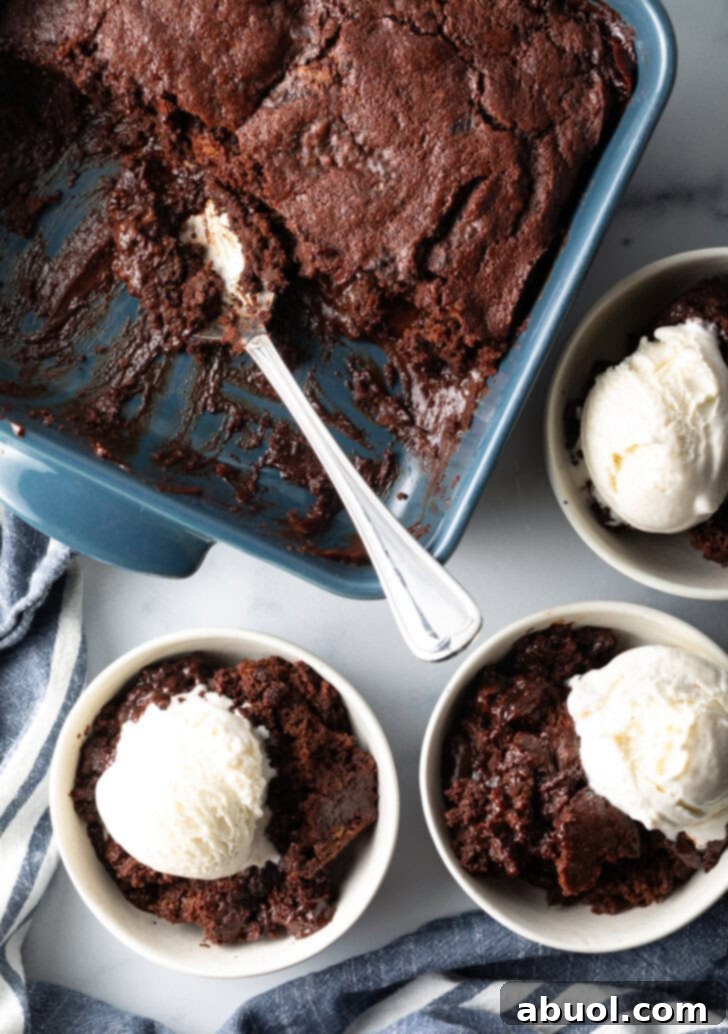 3 white bowls with servings of chocolate lava cake and a scoop of vanilla ice cream. Bowls are next to a baking pan with pudding cake and a metal spoon.