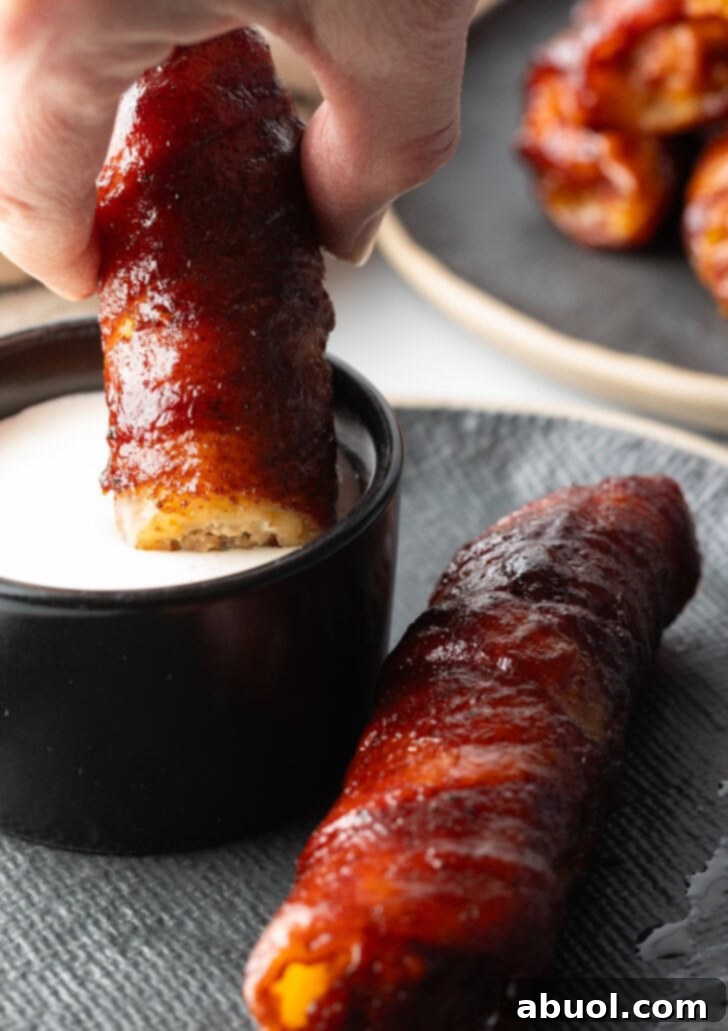 Hand dipping a smoked shotgun shell into a creamy white sauce.