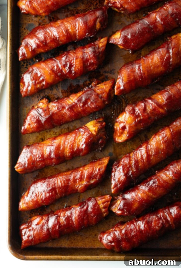 Top down view of 14 bacon wrapped smoked shells on a baking pan.