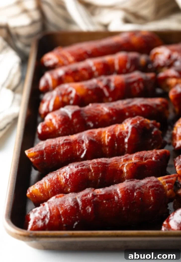 Baking pan with a row of 7 smoked shot gun shells covered in bbq sauce.