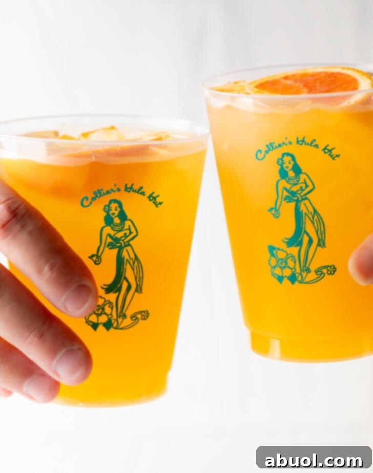 Two hands cheersing with glasses of vibrant vodka, juice, and seltzer drinks, celebrating a moment.
