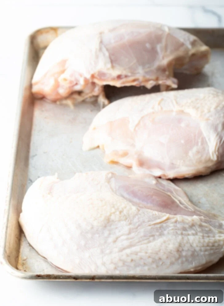 3 turkey breasts on a baking sheet.