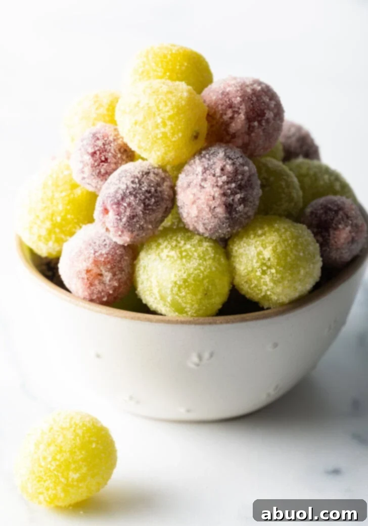 A visually appealing bowl filled with a generous mix of vibrant green and purple candy grapes, glistening under the light.