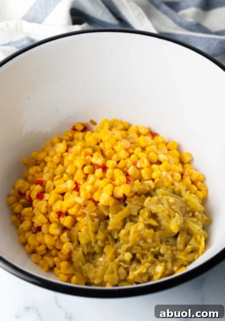 White bowl of mexicorn with chopped pickled jalapeno peppers.