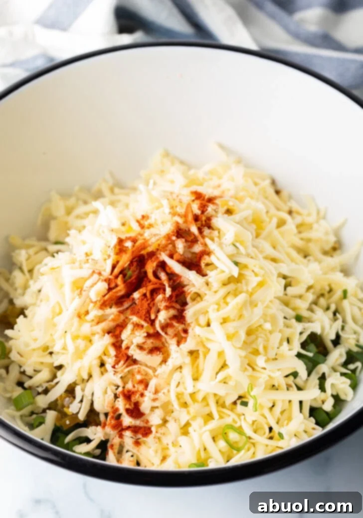 Spices and shredded cheese added to a bowl of remaining ingredients.