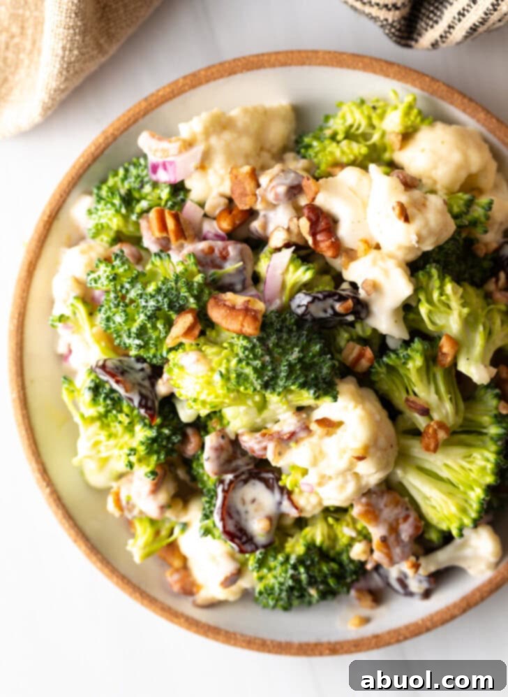 An inviting top-down shot of the finished broccoli cauliflower salad, glistening with its creamy dressing in a large bowl, ready to be enjoyed.