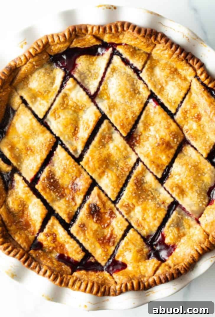 Top down view finished baked pie with diamond pattern crust.