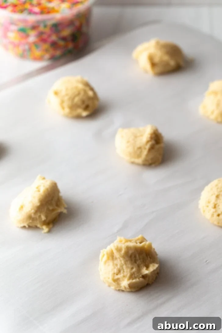 Luscious Cream Cheese Delights 5 Several raw cookie dough balls on a baking sheet.