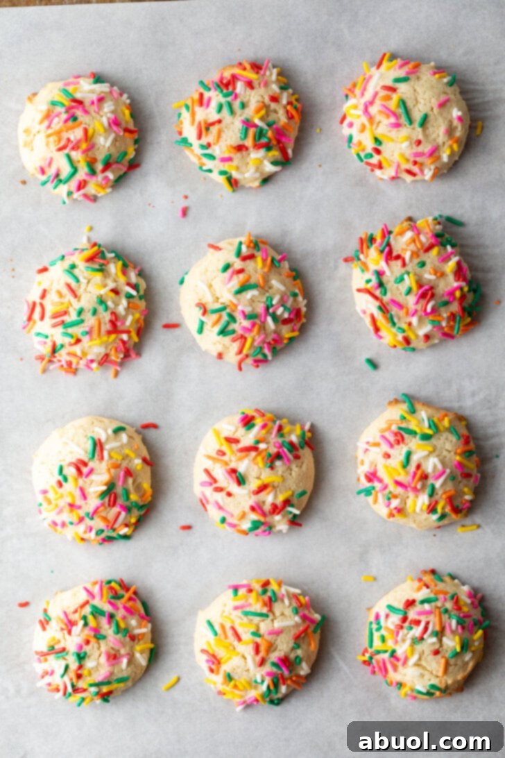 Luscious Cream Cheese Delights 7 Top down view 12 cream cheese cookies on a baking sheet, each topped with sprinkles.